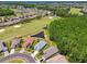 Aerial view of homes near a golf course and pond, surrounded by mature trees and lush landscaping in a desirable neighborhood at 1119 Dustan Pl, Trinity, FL 34655