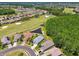 Aerial view of homes near a golf course and pond, surrounded by mature trees and lush landscaping in a desirable neighborhood at 1119 Dustan Pl, Trinity, FL 34655