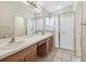Bathroom with double sinks in vanity, a large mirror, and a glass-enclosed shower at 1119 Dustan Pl, Trinity, FL 34655