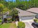 Aerial view of home showcasing its manicured lawn and garden, two-car garage, and well-maintained exterior at 1119 Dustan Pl, Trinity, FL 34655
