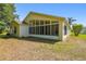 Back exterior view showcasing the sunroom and spacious backyard at 1119 Dustan Pl, Trinity, FL 34655