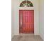 The red-colored front door with a glass side panel and an arched window above welcomes you inside at 1119 Dustan Pl, Trinity, FL 34655