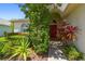 Inviting front entrance featuring a vibrant red door, lush landscaping, and a well-maintained walkway at 1119 Dustan Pl, Trinity, FL 34655