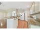 Open-concept kitchen layout with island, white appliances, and granite countertops overlooking the living room at 1119 Dustan Pl, Trinity, FL 34655