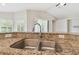 Close-up of the kitchen sink with granite countertop, stainless steel faucet, and view to backyard at 1119 Dustan Pl, Trinity, FL 34655