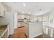 Bright kitchen with granite countertops, an island, and white cabinets overlooking the living room at 1119 Dustan Pl, Trinity, FL 34655