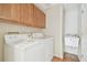 Functional laundry room with a GE washer and dryer, a wash basin, and oak-colored cabinets at 1119 Dustan Pl, Trinity, FL 34655