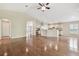 Open-concept living room with wood floors, ceiling fan, and kitchen with bar seating in a naturally lit space at 1119 Dustan Pl, Trinity, FL 34655