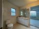 Bathroom with a double sink vanity and good natural lighting, and easy access to the primary bedroom at 11213 Brooklawn Dr, Hudson, FL 34667