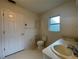 Bathroom featuring a double sink vanity, a separate toilet area and a frosted window at 11213 Brooklawn Dr, Hudson, FL 34667