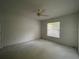 Neutral bedroom features a ceiling fan and a window providing plenty of natural light at 11213 Brooklawn Dr, Hudson, FL 34667