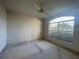 Bedroom featuring a large arched window with lots of natural light and a ceiling fan at 11213 Brooklawn Dr, Hudson, FL 34667