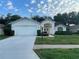 Attractive home featuring a two-car garage, landscaped front yard, and a welcoming double-door entryway at 11213 Brooklawn Dr, Hudson, FL 34667