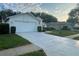 Spacious driveway leads to this home with an attached two-car garage and manicured lawn at 11213 Brooklawn Dr, Hudson, FL 34667