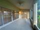 The screened patio has a ceiling fan, tiled floor, and sliding glass doors at 11213 Brooklawn Dr, Hudson, FL 34667