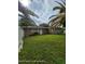 A vast backyard featuring a stone exterior and well-maintained green space, great for outdoor activities at 1127 Lodge Cir, Spring Hill, FL 34606