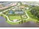 Aerial view of the community showing the tennis courts, playground, walking paths, and greenery at 11325 Juglans Dr, Odessa, FL 33556