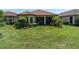 Well-manicured lawn in backyard, complemented by a covered patio for relaxed outdoor living and entertaining at 11325 Juglans Dr, Odessa, FL 33556