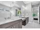 Bright bathroom with dual sinks, large mirror, and views to bedroom at 11325 Juglans Dr, Odessa, FL 33556