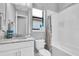 Bathroom with tub and shower, bright light, and a white granite vanity at 11325 Juglans Dr, Odessa, FL 33556