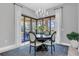An elegant dining area with a round table, four chairs, large windows, and natural light at 11325 Juglans Dr, Odessa, FL 33556
