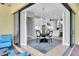 Dining room area with a round table and an elegant chandelier, as well as a view into the bright white kitchen at 11325 Juglans Dr, Odessa, FL 33556