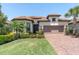 Charming home with a tile roof, well-maintained lawn, and a brick driveway at 11325 Juglans Dr, Odessa, FL 33556