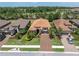 An eye-level view of a home with well-manicured landscaping, a terra cotta roof, and a paved driveway with parked vehicles at 11325 Juglans Dr, Odessa, FL 33556