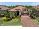 Beautiful single-story home with a tile roof, well-manicured lawn, and a brick driveway at 11325 Juglans Dr, Odessa, FL 33556