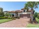 Inviting single-Gathering home features a paver driveway, two-car garage, and well-maintained landscaping at 11325 Juglans Dr, Odessa, FL 33556
