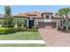 Attractive exterior showcasing a tile roof, paver driveway, and a beautifully landscaped front yard at 11325 Juglans Dr, Odessa, FL 33556