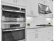 This kitchen features built-in stainless steel appliances, white cabinets, granite countertops, and a gas cooktop at 11325 Juglans Dr, Odessa, FL 33556
