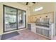 Covered outdoor kitchen with a built-in grill, sink, and counter space, perfect for entertaining at 11325 Juglans Dr, Odessa, FL 33556