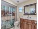 Bathroom with a decorative anchor shower curtain, white tile shower, and a vanity with a dark wood frame mirror at 12191 Monarco Ln, Spring Hill, FL 34609