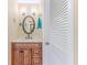 Bright bathroom with a vanity, an oval mirror and a shutter door for added elegance at 12191 Monarco Ln, Spring Hill, FL 34609
