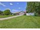 Spacious front yard view featuring a well-maintained lawn and mature trees surrounding the property at 12191 Monarco Ln, Spring Hill, FL 34609