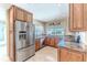 Bright kitchen with stainless steel appliances, granite countertops, and tiled floors under recessed lighting at 12191 Monarco Ln, Spring Hill, FL 34609