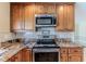 Well-equipped kitchen features stainless steel appliances, granite countertops, and custom cabinetry at 12191 Monarco Ln, Spring Hill, FL 34609