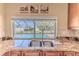Kitchen sink featuring granite countertops with a serene view of the screened-in pool and backyard at 12191 Monarco Ln, Spring Hill, FL 34609