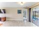 Cozy living room area with a large television, tile flooring, and sliding door access to an outdoor patio at 12191 Monarco Ln, Spring Hill, FL 34609