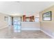 Open-concept living space with polished tile flooring, neutral walls, and a partial view of the kitchen at 12191 Monarco Ln, Spring Hill, FL 34609