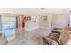 Open-concept living room with polished tile flooring, neutral walls, and a view of the pool area at 12191 Monarco Ln, Spring Hill, FL 34609