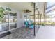 Covered patio features decorative ceiling fan, textured stone floor and peaceful seating area at 12191 Monarco Ln, Spring Hill, FL 34609