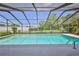 Screened-in swimming pool is surrounded by well-maintained landscaping and tall privacy fence at 12191 Monarco Ln, Spring Hill, FL 34609