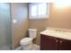 Bathroom with a tiled shower, toilet, a window with faux wood blinds, and a vanity at 12210 Quail Run Row, Hudson, FL 34667
