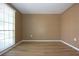 Bedroom with light-colored walls, wood-look floors, large windows, and modern baseboards at 12210 Quail Run Row, Hudson, FL 34667