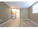 Bedroom with light-colored walls, wood-look floors, large windows, and access to an ensuite bathroom at 12210 Quail Run Row, Hudson, FL 34667