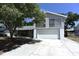 Two story home with an attached two car garage, mature trees, and a concrete driveway at 12210 Quail Run Row, Hudson, FL 34667