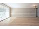 Spacious living room with laminate flooring, crown molding, and a large window with light shining through at 12210 Quail Run Row, Hudson, FL 34667
