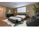 Comfortable main bedroom staged with a king bed, bench, dresser, and accent chairs at 12210 Quail Run Row, Hudson, FL 34667